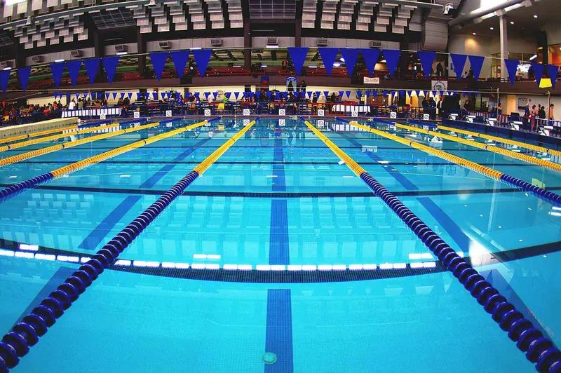 An empty competitive swimming pool with lane ropes in place